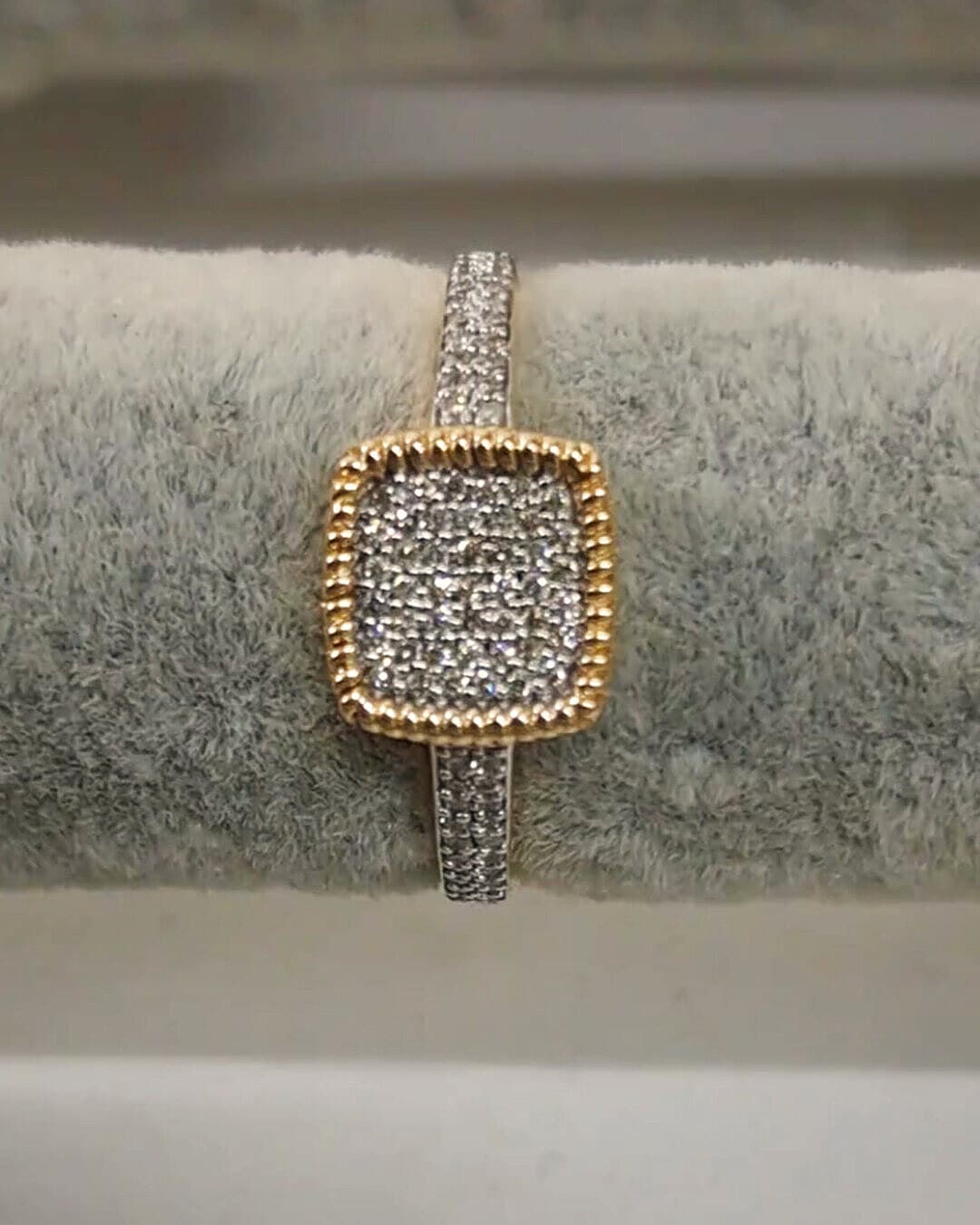 A two-tone gold ring with a cushion-shaped pavé diamond cluster