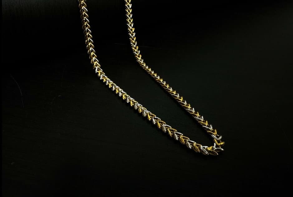 A fine two-tone gold wheat chain on black
