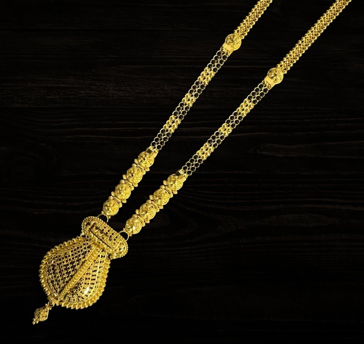 A 22ct gold mangalsutra with a large filigree pendant and black bead strands