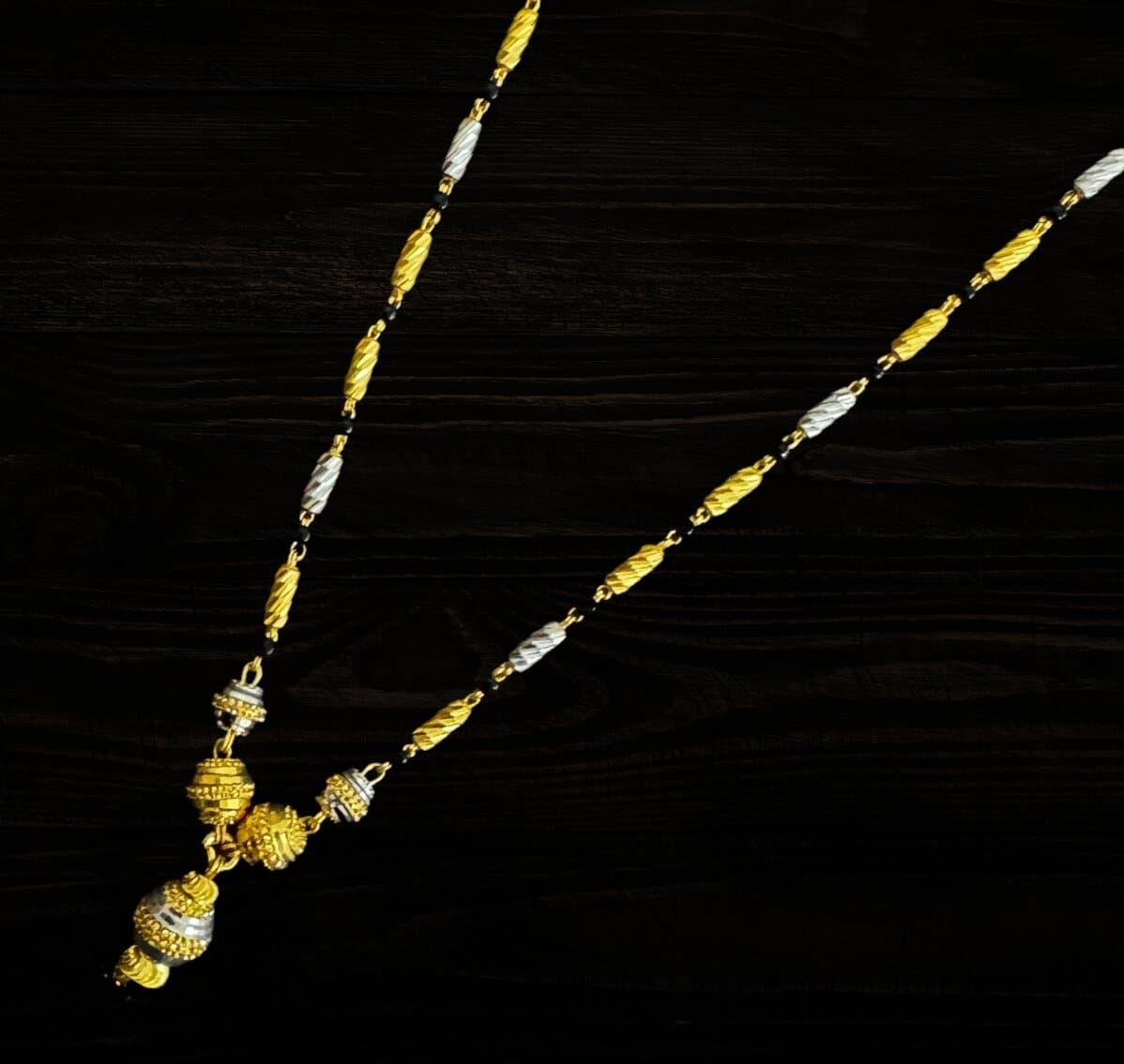 A 22ct mangalsutra of yellow and white-gold barrel beads