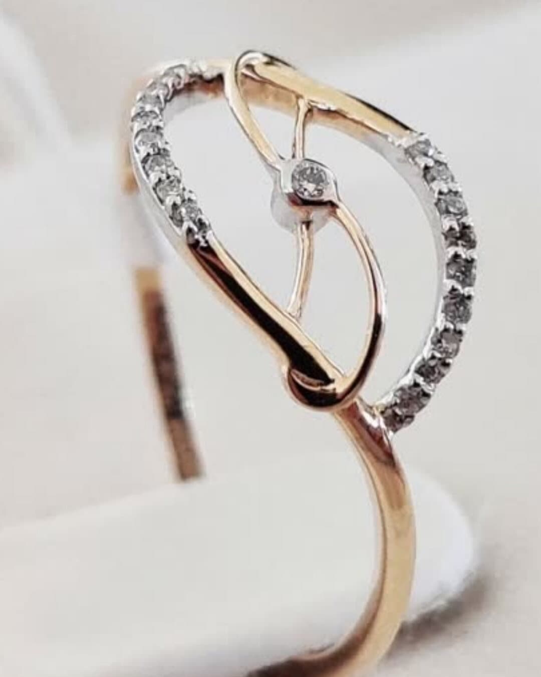 A rose and white gold ring with a diamond-set leaf swirl